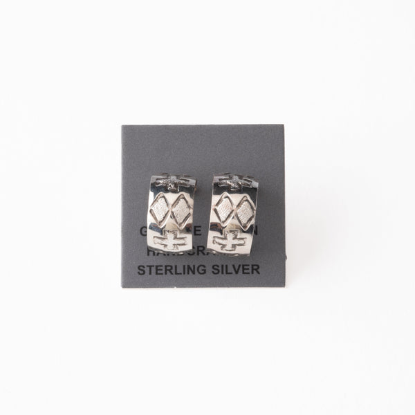 Pair of silver earrings with stamped design on a gray card with 'Sterling Silver' text.