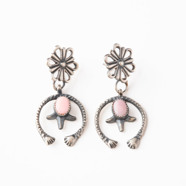 Pair of silver earrings with pink stones on a white background