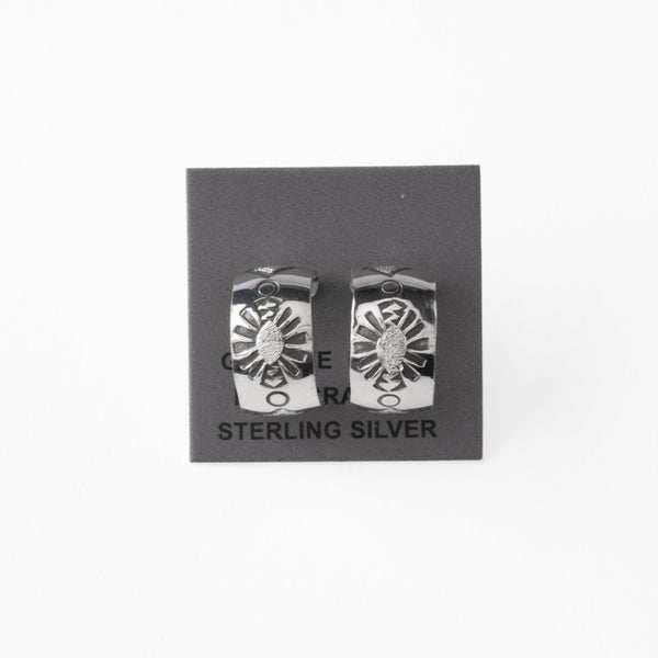 Pair of silver earrings with stamped design on a gray card with 'Sterling Silver' text.