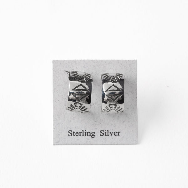 Pair of silver earrings with stamped design on a gray card with 'Sterling Silver' text.