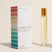 Perfume bottle and packaging with 'Sunset Sorbet' branding on a beige background