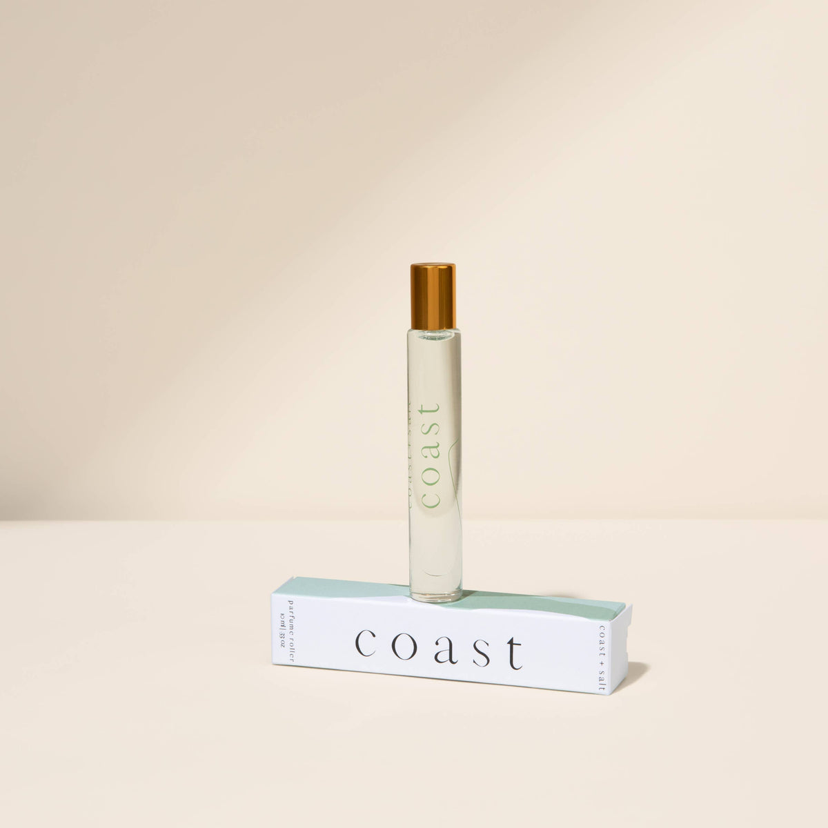 Perfume bottle labeled 'Coast' on a beige background
