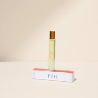 Roll-on perfume bottle with red cap and white label on a beige background