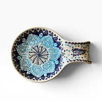 Ceramic spoon rest with blue floral pattern on a white background
