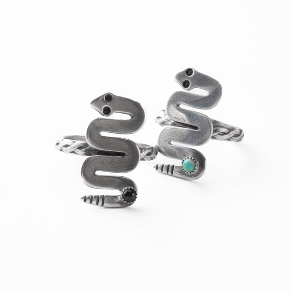 Silver snake-shaped rings with a turquoise stone on a white background
