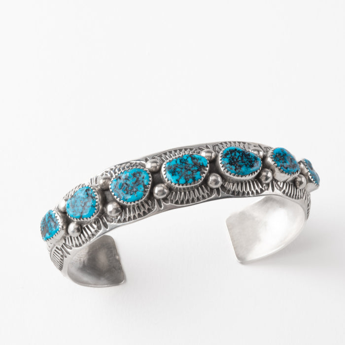 Silver bracelet with turquoise stones on a white background