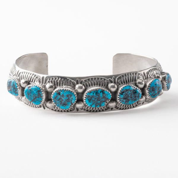 Silver bracelet with turquoise stones on a white background