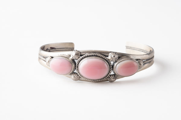 Silver bracelet with pink stones on a white background