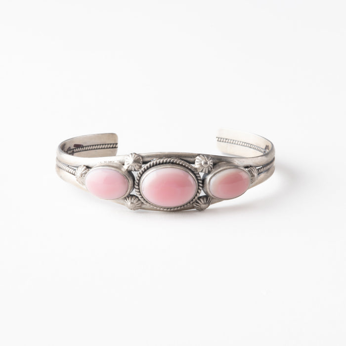 Silver bracelet with pink stones on a white background