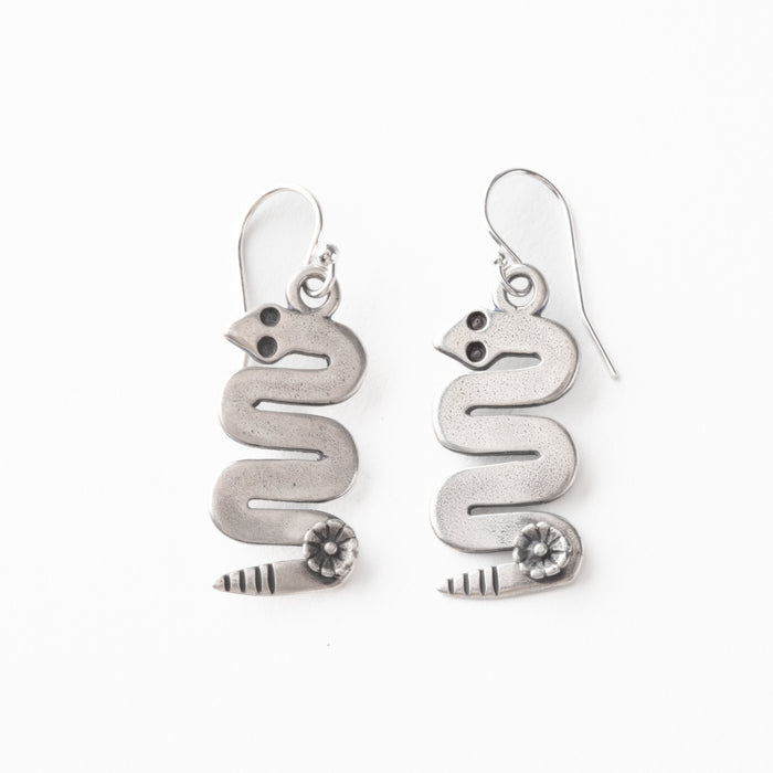 Silver snake-shaped earrings on a white background
