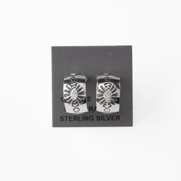 Pair of silver earrings with stamped design on a gray card with 'Sterling Silver' text.
