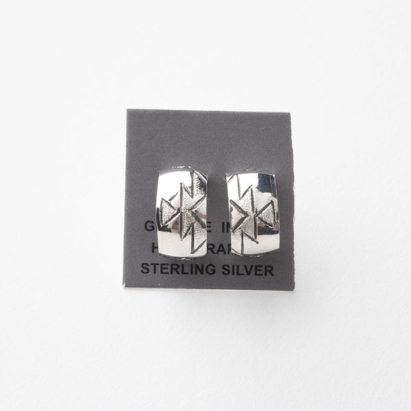 Pair of silver earrings with stamped design on a gray card with 'Sterling Silver' text.
