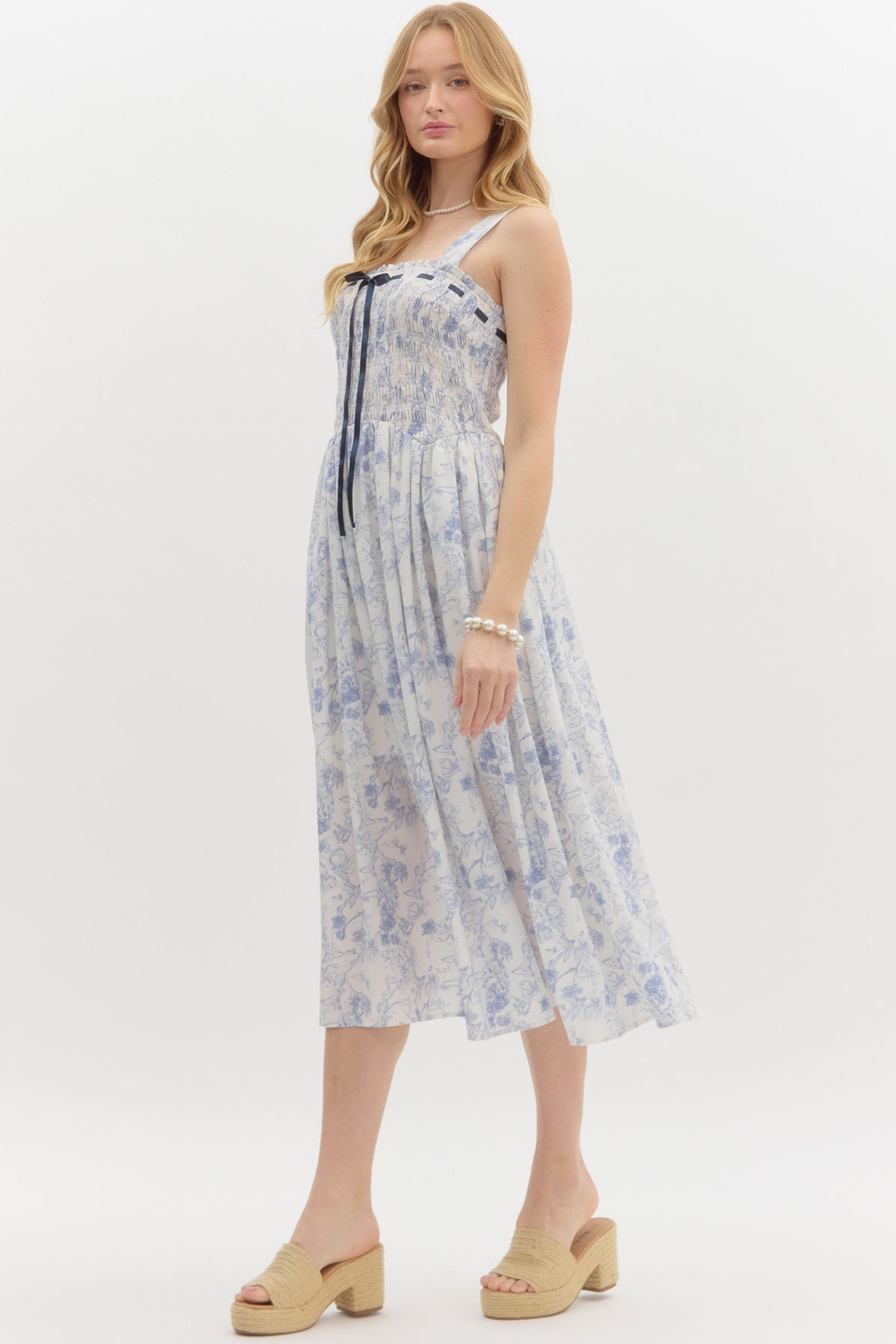 Blue: Floral print adjustable shoulder strap pullover midi dress. Adjustable satin bow smocked top. Lined. Woven. Non-sheer. Lightweight.