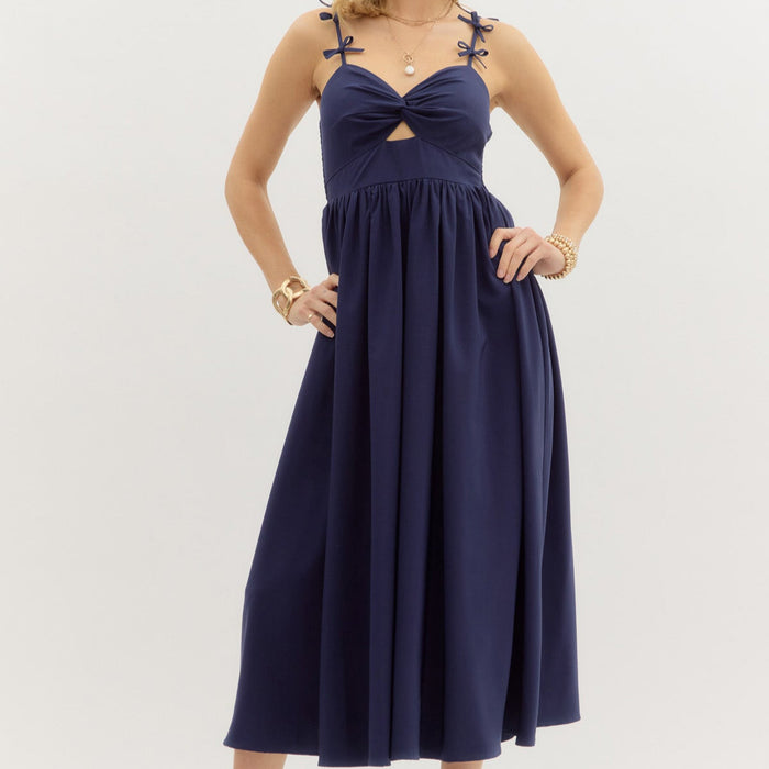 Navy: Solid twist front top pullover midi dress featuring bow accented adjustable shoulder strap. Smocked back closure. Lined. Woven. Non-sheer. Lightweight.