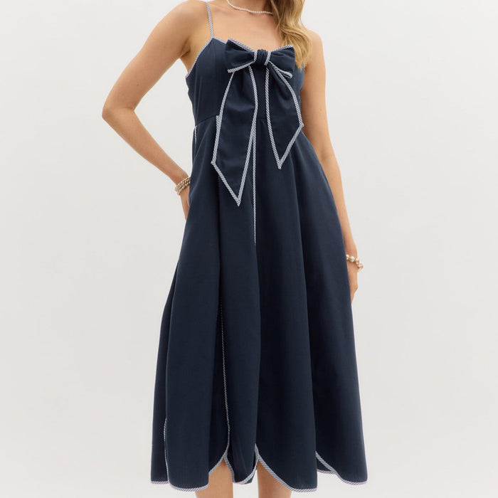 Navy: Solid bow front scallop hem midi dress featuring contrast accent adjustable shoulder strap and finish edge. Smocked back closure. Pockets at sides. Lined. Woven. Non-sheer. Lightweight.