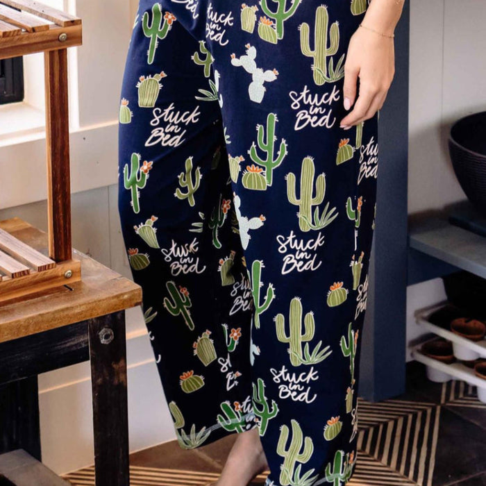 A pair of women's pajama pants with an all over cactus design, featuring a drawstring waist and a contrasting front pocket.