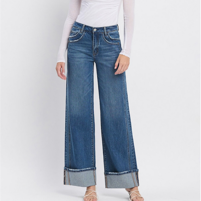 Woman wearing a white top and blue jeans on a white background