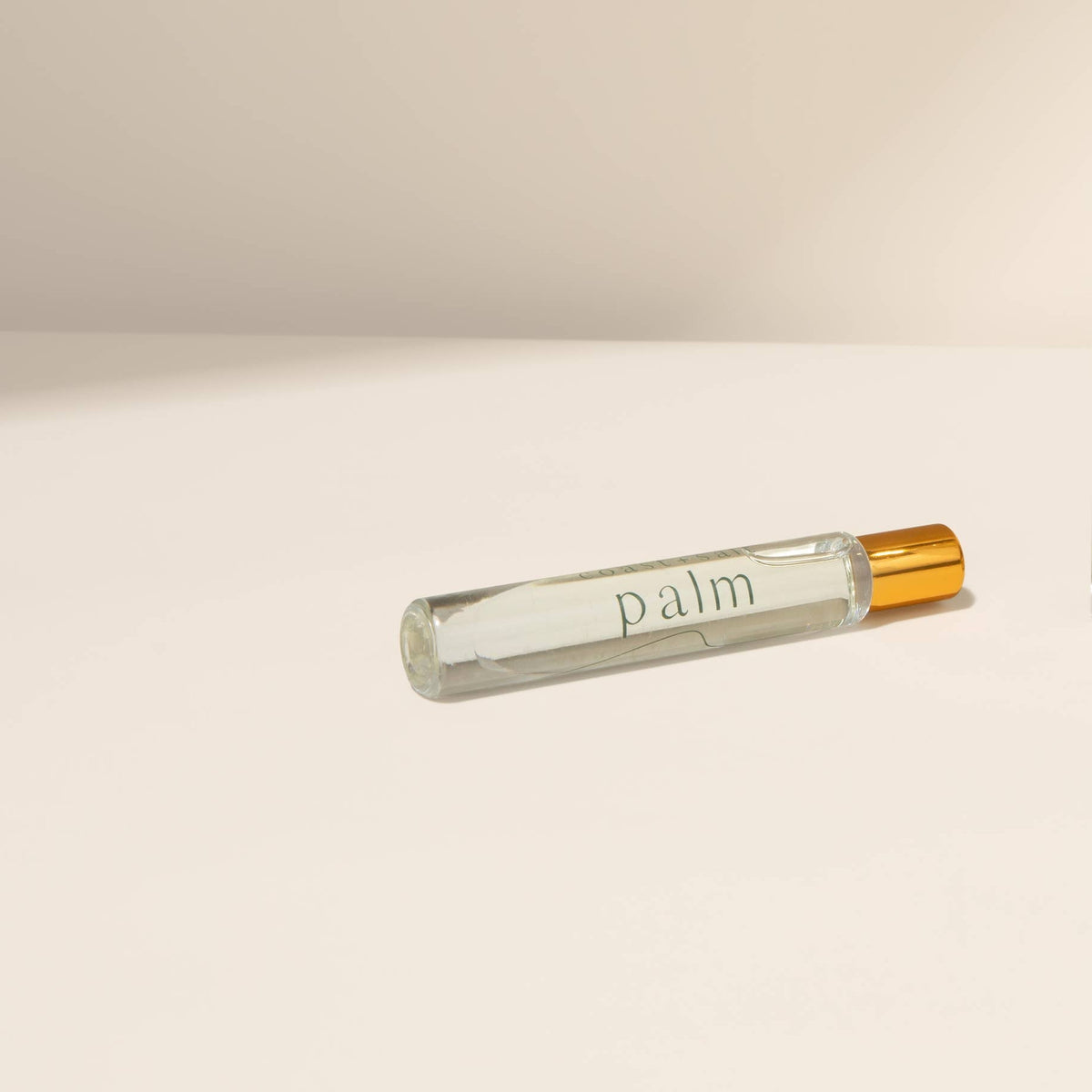 Perfume bottle and travel-sized version on a beige background